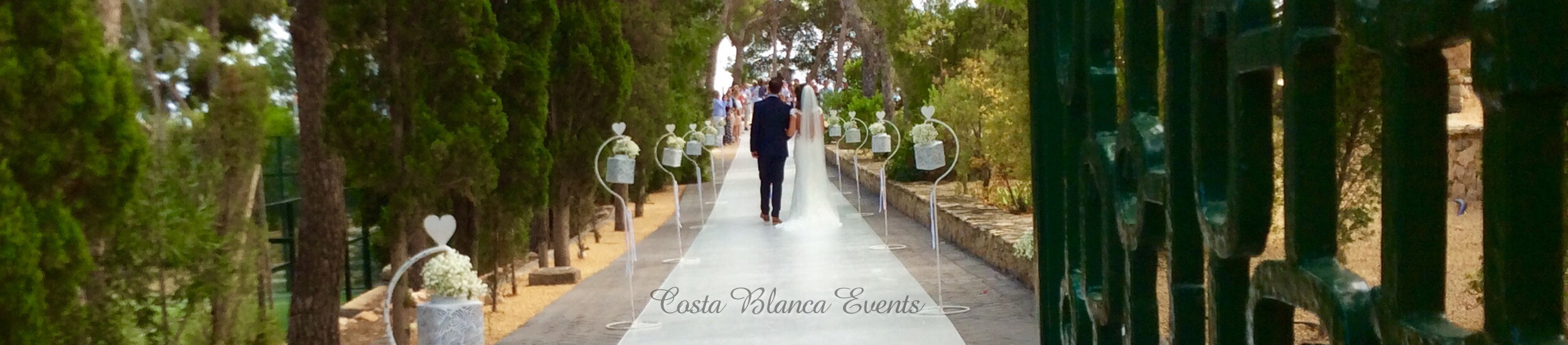 Bride and father of the bride walking on the driveway of a private wedding venue in Spain